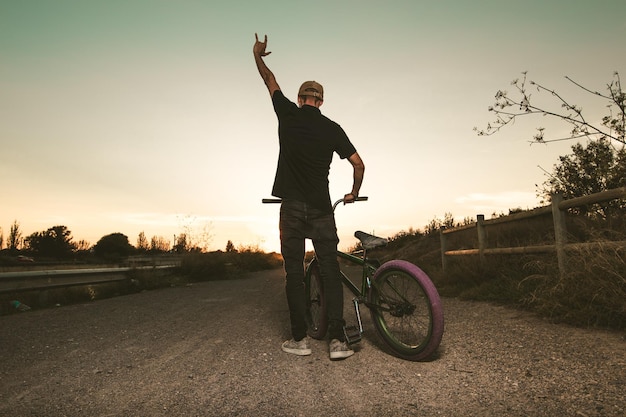 Foto uomo in bicicletta al tramonto