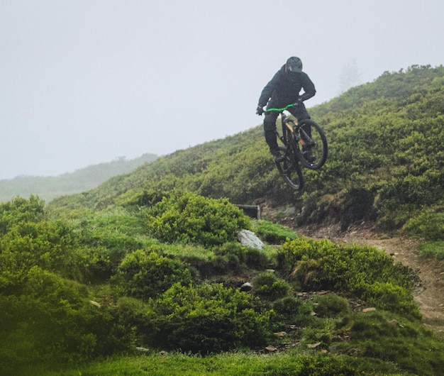 Photo man riding bicycle on a trail downhill