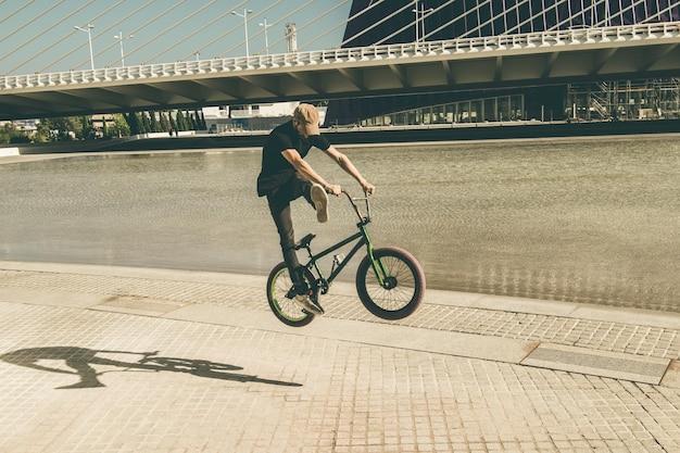 都市の歩道でBMXサイクルに乗っている男性