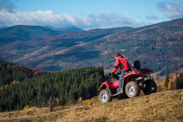 Photo man riding down on an atv the hilly road