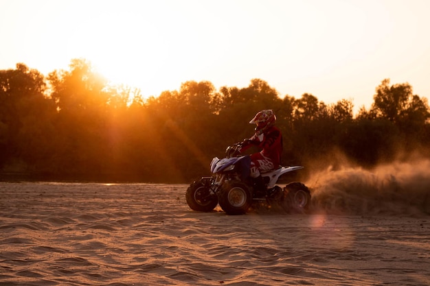Man riding motorcycle against sky during sunset