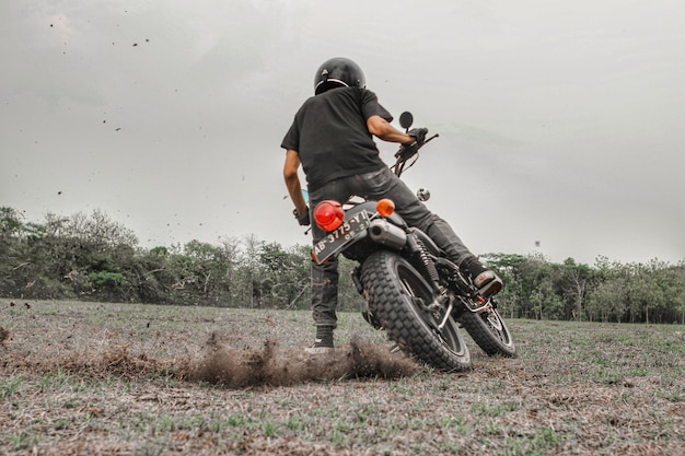 Photo man riding motorcycle on field