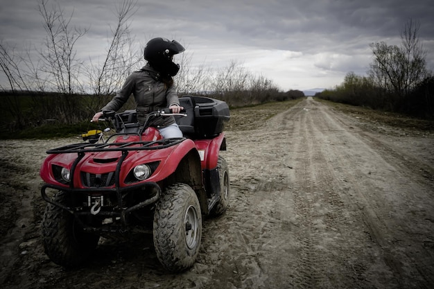 Man riding quadbike on field against sky