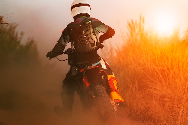 man riding sport enduro motorcycle on dirt track