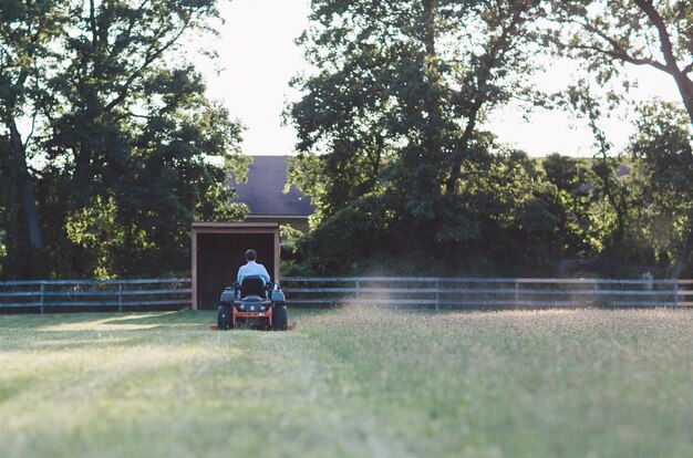 Photo man riding vehicle on grassy field