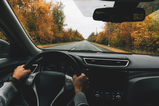 Man rijdende auto op de landweg in de herfst