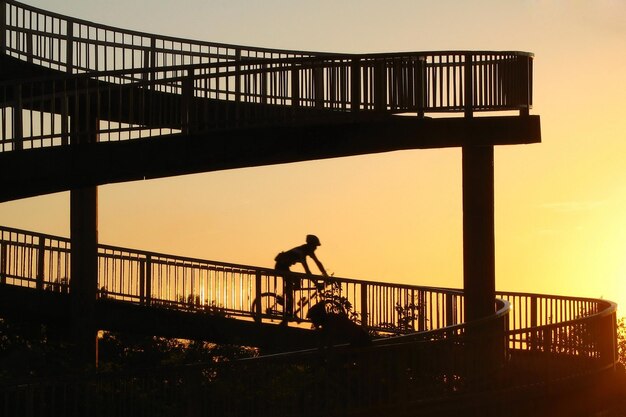 Man rijdt fiets bij zonsondergang