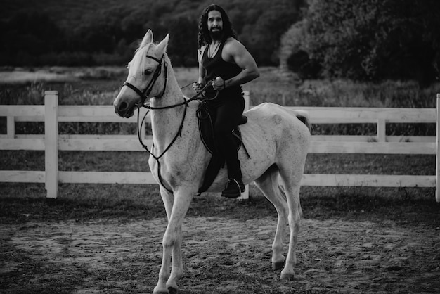 Man rijdt op een paard hunky cowboy rijdt paard landleven concept