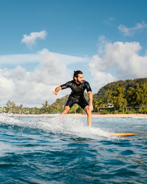 Foto man rijdt op zijn surfplank en heeft een goede tijd verticaal schot