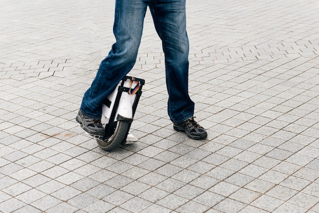 Man rijdt snel op elektrische eenwieler op straat.