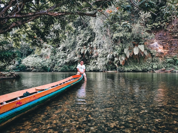 Foto uomo nel fiume contro gli alberi