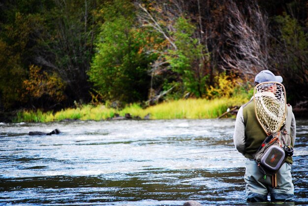 man on river against trees