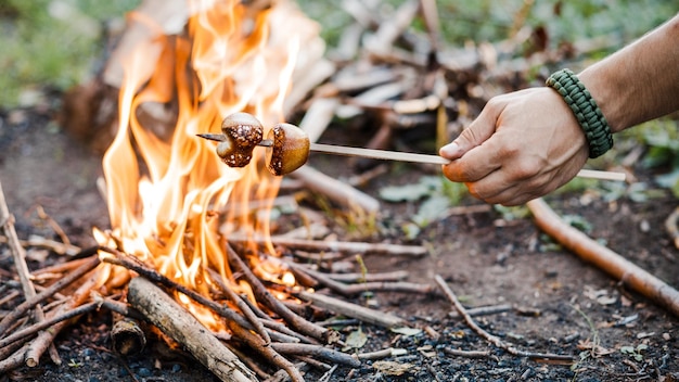 A man roasts marshmallows on a fire near the tent