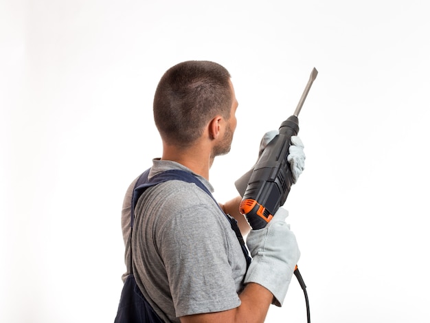 A man in robo-like clothes holds a hand punch, ready to work, on a white background.