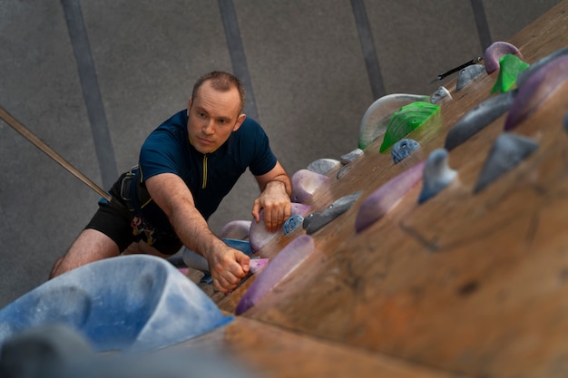 Man rock climbing indoors in the arena