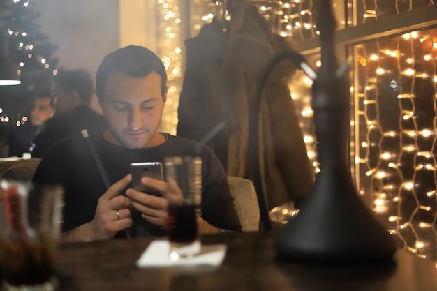 Man rookpijp van waterpijp in een nachtcafé