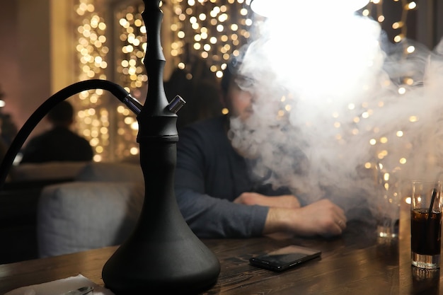 Man rookpijp van waterpijp in een nachtcafé