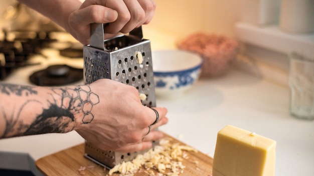 Man rubbing cheese on a grater