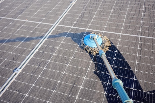 Man ruim de zonnepanelen op die vuil zijn met stof en vogelpoep