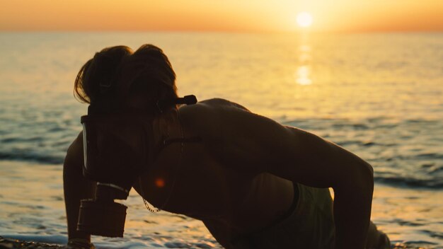 Foto uomo che corre all'alba sulla spiaggia con una maschera antigas