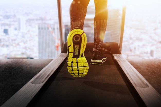 L'uomo corre con il tapis roulant in palestra in una giornata di sole