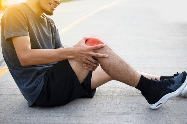 Man Runner joggen om te oefenen op de ochtend maar ongevallen Kniepijn