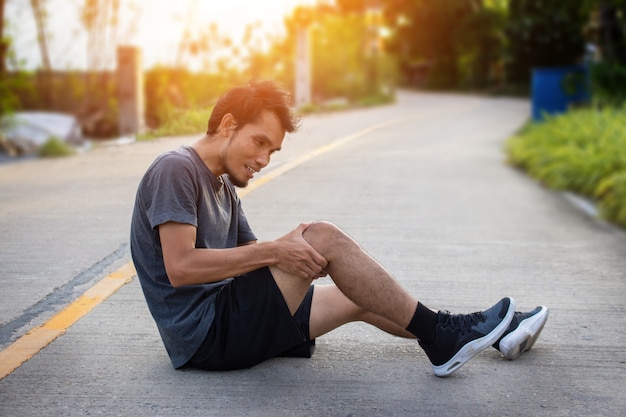 Man runner joggen om te oefenen op ochtend maar ongeluk kniepijn tijdens het hardlopen