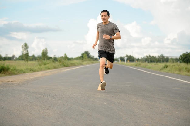 健康への道を走る男性ランナー、路上で運動をしている若者たち。