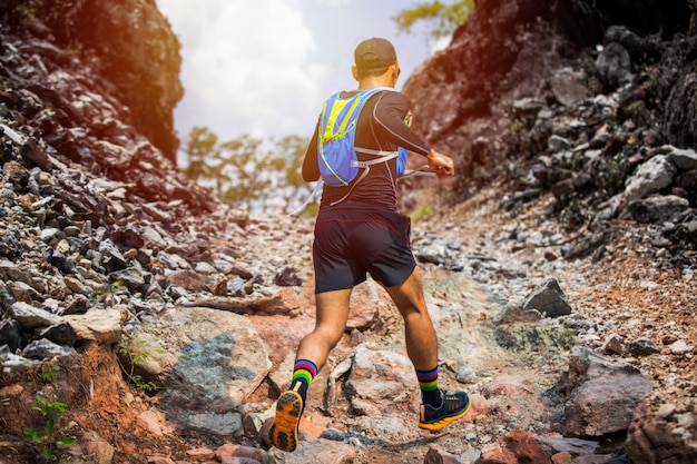 A man Runner of Trail and athlete's feet wearing sports shoes for trail running in the forest