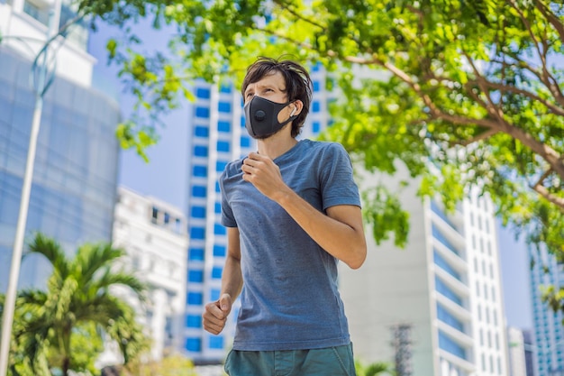 의료 마스크를 착용한 남성 달리기 선수가 도시 코로나 바이러스의 배경에서 도시에서 달리고 있습니다.