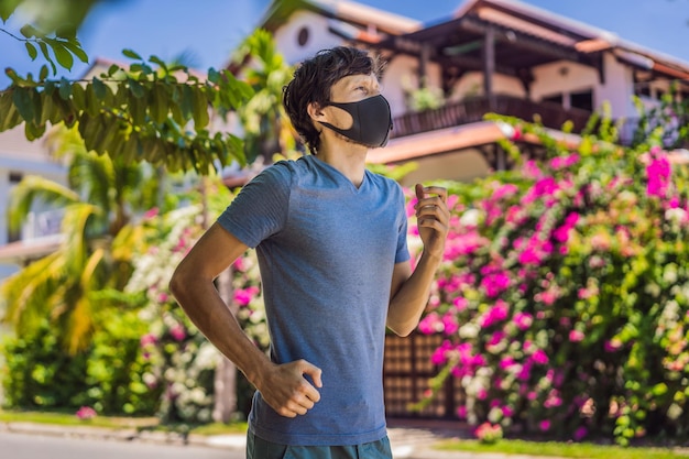 Man runner wearing medical mask running in the park coronavirus pandemic covid sport active life in