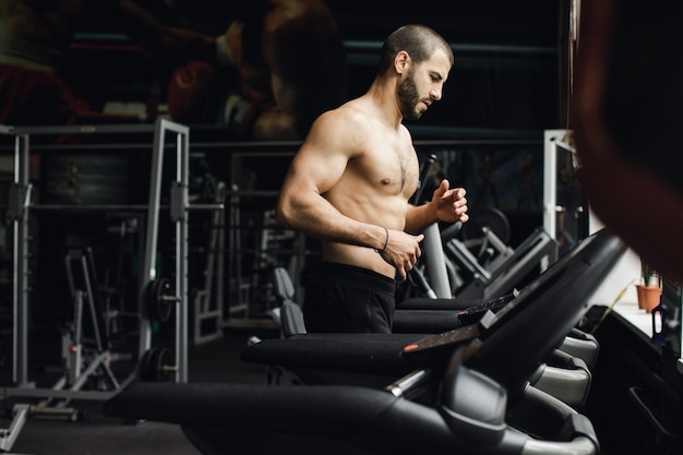 Man running in a gym on a treadmill concept for exercising fitness and healthy lifestyle 