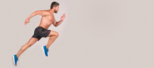 コピースペーススポーツマンの男ランナーが成功するか、灰色の背景のコピースペーススポーツで高くジャンプする男ランニングとジャンプバナー