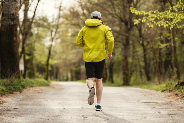 Uomo che corre al mattino in un parco