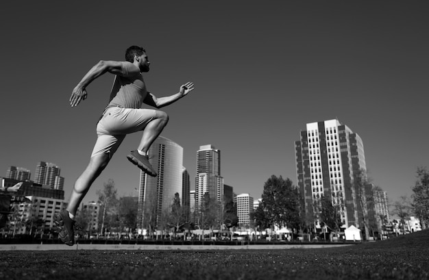 Man running outdoors on the town jogging in a city park