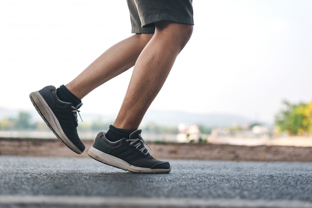 Foto uomo che corre sul parco con close up scarpe