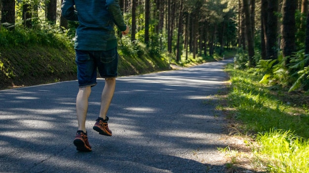 自然の中で道路を走る男ライフスタイルとして野外を走る健康的な習慣