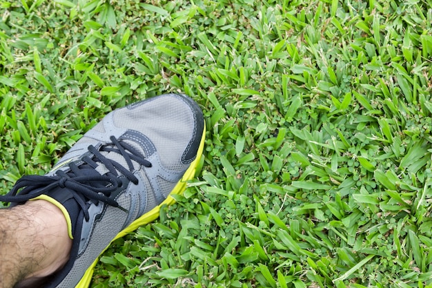 man running shoe stand on grass 