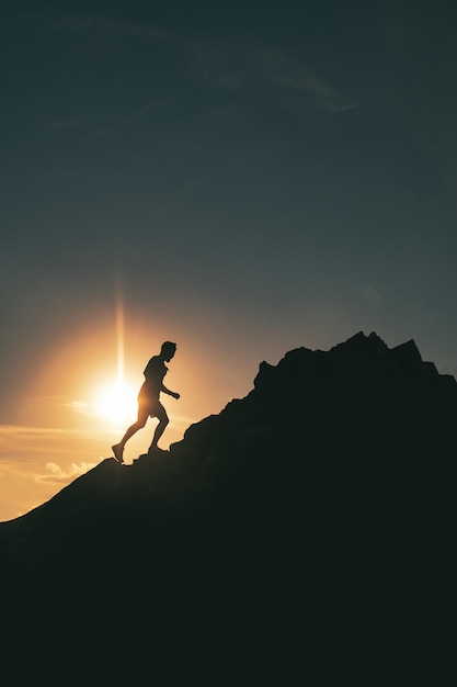 A man runs among the rocks in a colorful mountain sunset