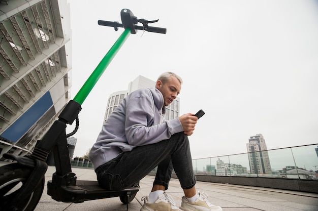 Man rust na een lange reis door de stad op een gehuurde scooter