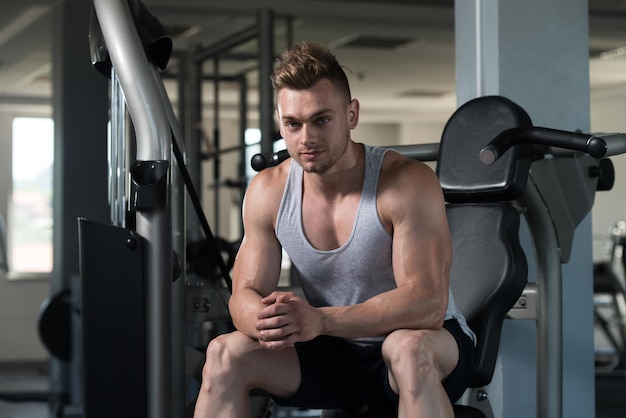 Man rust op bankje in fitnesscentrum