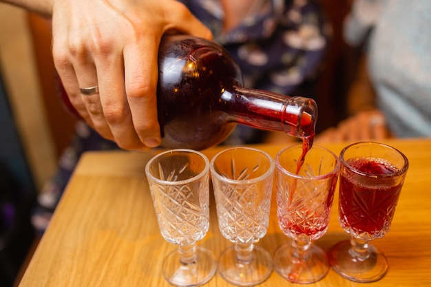 Un uomo con una camicia dall'aspetto rustico versa del whisky nei bicchieri il whisky beve una bevanda alcolica