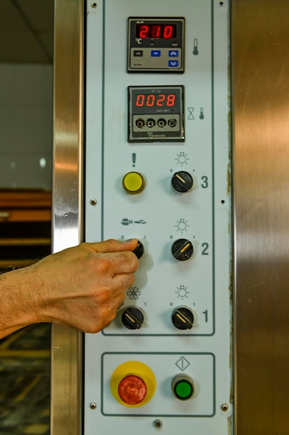 Man's finger touching oven control button