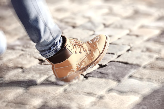 man’s foot in a shoe on a paving block, a pedestrian,