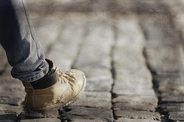 man’s foot in a shoe on a paving block, a pedestrian,