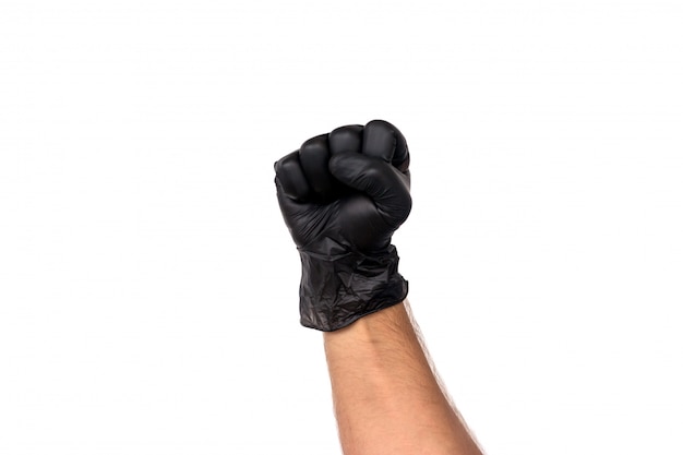 Man's hand in a black glove is clenched into a fist. Isolate on white background. Concept of power and victory