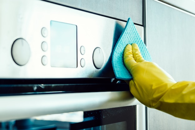 Man's hand cleaning the kitchen oven