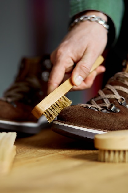 Man's hand cleans suede shoes with brush