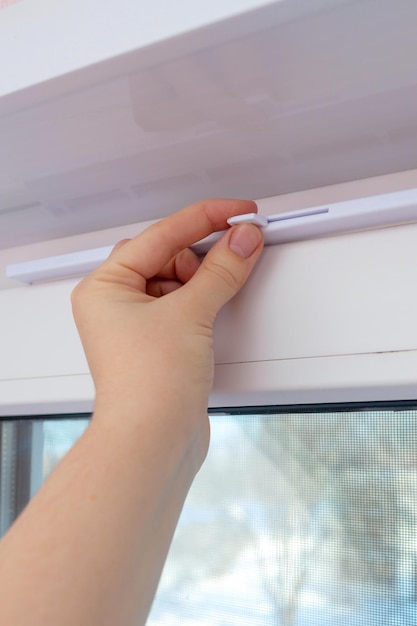A man's hand closes the inlet vent adjustable valve over the white plastic window