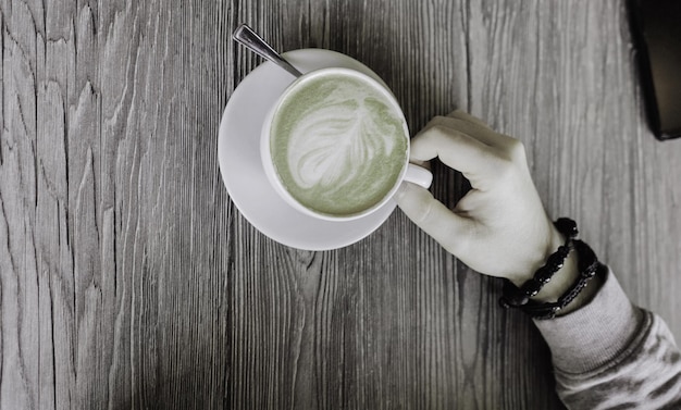 Man's hand next to a coffee cup